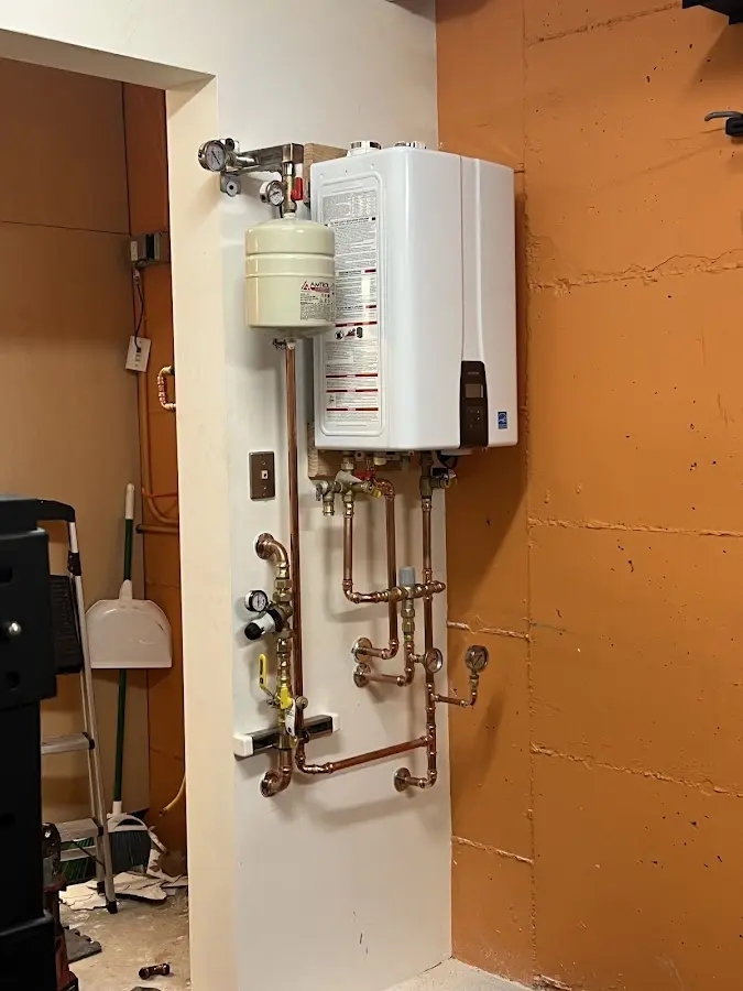 Plumbing technician inspecting water heater connections in Lansdowne